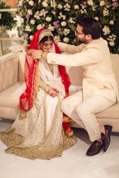 a man kneeling down next to a woman in a wedding dress