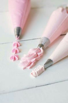 two pink umbrellas and one is made out of paper with pencils sticking out of them