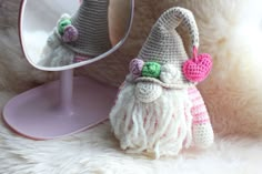 a crocheted gnome purse sitting next to a mirror