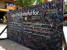 a blackboard with writing on it in front of a building