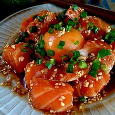 salmon with sesame seeds and green onions on a plate