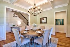 a dining room table with four chairs and a chandelier