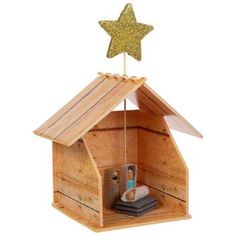 a wooden birdhouse with a star on top and the door open to it's roof