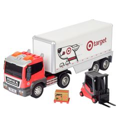 a red and white toy truck next to a small black car with a dog on the back