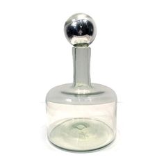 a glass bottle with a metal ball on it's top and the bottom is empty