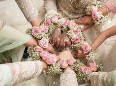 a group of people standing around each other with flowers in the middle of their hands