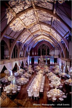 the inside of a building with tables and chairs set up for a formal function in front of a christmas tree