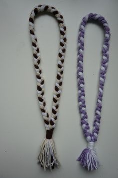 two necklaces with tassels are shown on a white surface, one is purple and the other is brown