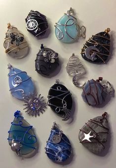 twelve handmade glass ornament ornaments displayed on a white surface with wire wrapped around them