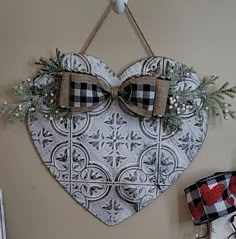 a heart shaped decoration with bow ties hanging on the wall