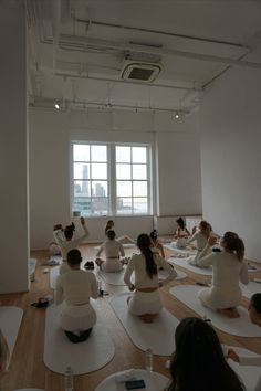 a group of people sitting on yoga mats in a room