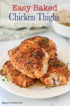 chicken thighs on a white plate with parsley in the background and text overlay that reads easy baked chicken thighs