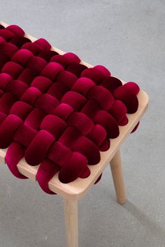 a red cushion sitting on top of a wooden chair