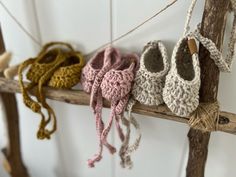 several crocheted baby shoes hanging on a branch