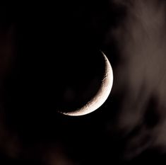 the moon is seen through clouds in this black and white photo