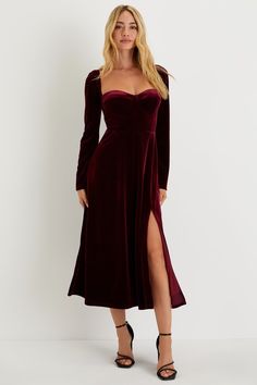 a woman wearing a long sleeved velvet dress with thigh high slits and an asymmetrical neckline