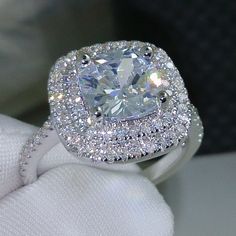 a cushion cut diamond surrounded by pave set diamonds