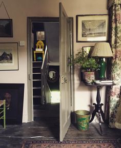 an open door leading to a living room with pictures on the wall and a lamp