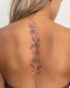 the back of a woman's shoulder with flowers and leaves on her left side