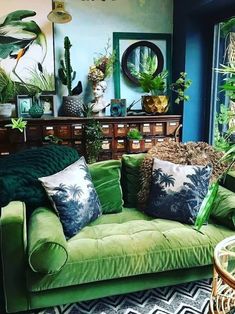 a living room filled with lots of green furniture and plants on top of the couch