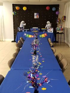 a long table is set up with balloons and confetti