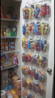 a pantry filled with lots of food next to a white refrigerator freezer covered in plastic bags