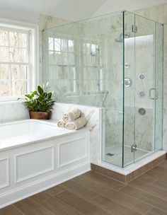 a bathroom with a bathtub, sink and toilet next to a window in it