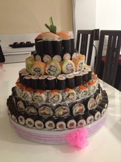 there is a large cake made out of sushi rolls on top of each other