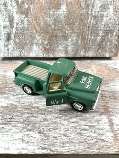 a green toy truck sitting on top of a wooden table