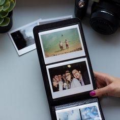 a person holding an open book with pictures on it and two polaroid frames in front of them