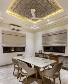 a dining room table and chairs with roman blinds