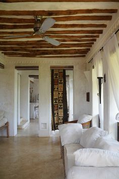 a living room filled with lots of white furniture and pillows on top of it's walls