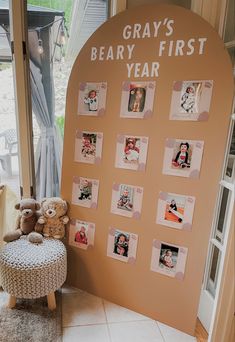 a teddy bear sitting next to a wall with pictures on it