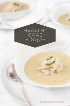 a white plate topped with soup next to silver spoons