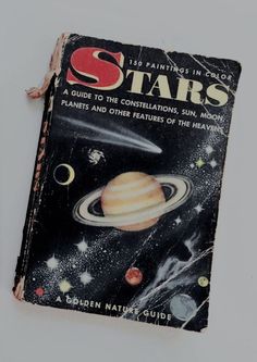 an old book that is sitting on a table with the cover pulled up to look like it's from outer space