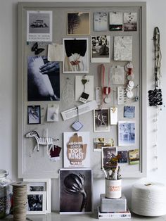 a bulletin board with pictures, photos and yarn on it's sides next to a potted plant