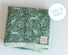 the green and white fabric is made to order with an image of animals on it