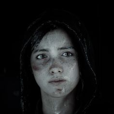 a woman with freckles on her face is staring at the camera while covered in mud