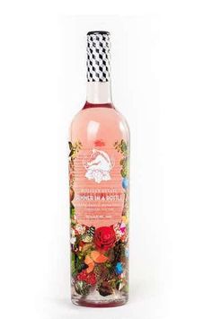 a bottle of pink liquid with flowers on the top and black and white checkered cap