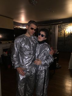 a man and woman in shiny silver outfits