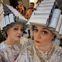 two women wearing tinfoil hats and silver sequins on their heads are looking at the camera