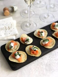 small appetizers with smoked salmon and cream cheese are arranged on a black platter