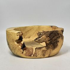 a wooden bowl that is made out of wood and has two animals on it's side