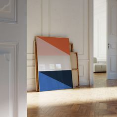 an empty room with a painting on the floor in front of it and a door leading to another room