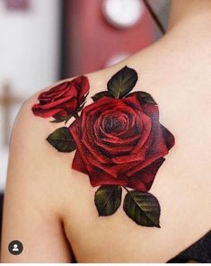 a woman with a rose tattoo on her upper back shoulder and arm, it is dark red