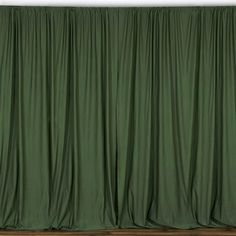 a green curtain is hanging on the wall in front of a white wall and wooden floor