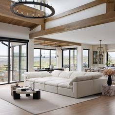 a living room filled with white furniture and lots of glass doors leading to a balcony