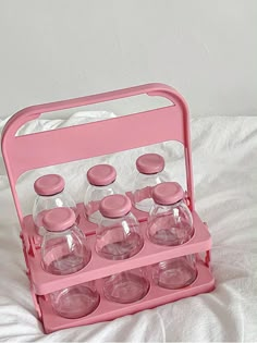 a pink plastic case filled with glasses on top of a bed