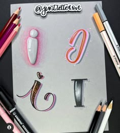 some colored pencils are laying on top of a piece of paper that has the letter j in it