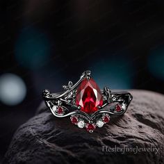 a red stone ring sitting on top of a rock